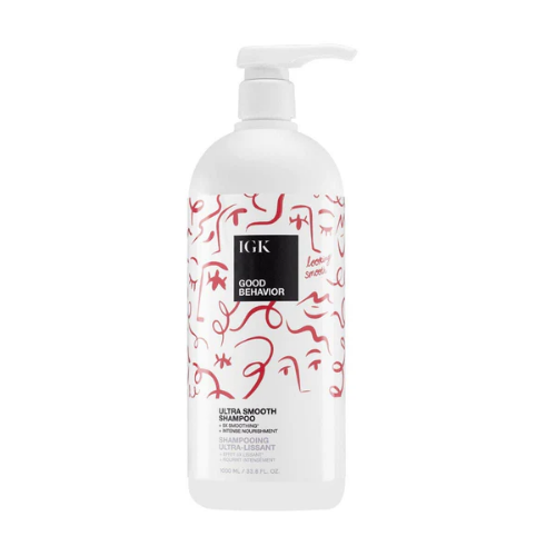 Bottle of IGK Good Behavior Ultra Smooth Shampoo with abstract red designs.