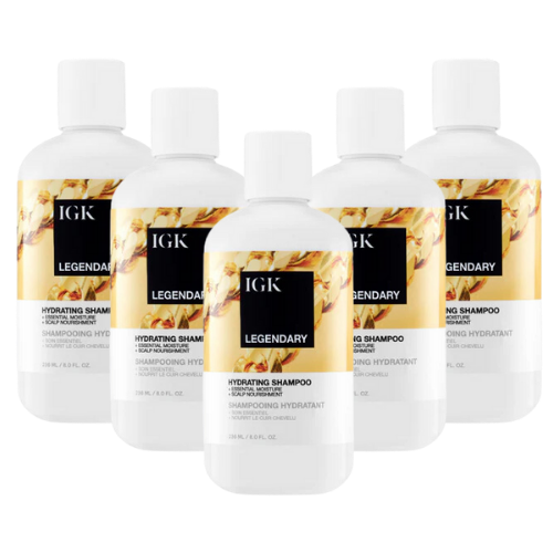 Five bottles of IGK Legendary Hydrating Shampoo with floral design labels.